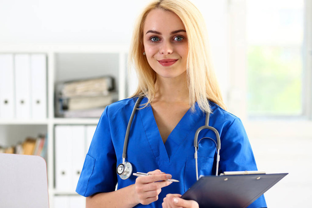 Beautiful smiling female doctor hold clipboard - 写真・画像