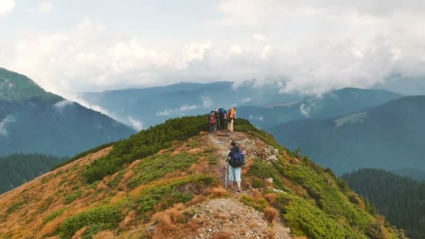 Een groep toeristen met rugzakken bovenop een berg bekijken van een landschap. Karpaten, Oekraïne - Video