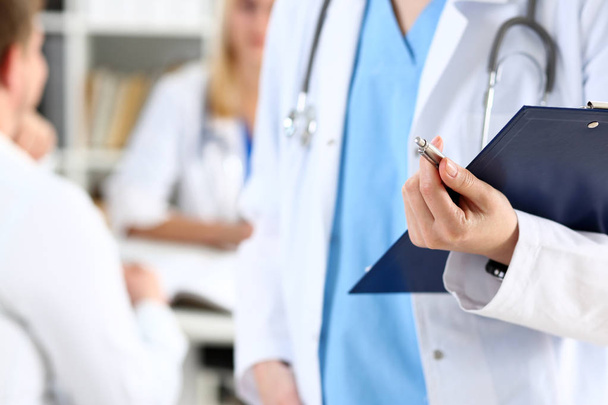 Médica feminina segurar clipboard pad e preencher lista de histórico médico
 - Foto, Imagem