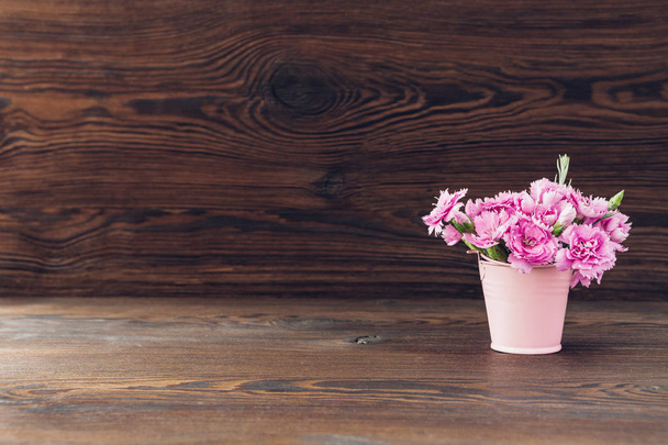 bouquet of pink Carnation flowers in vase on wood background. Empty space for text - Fotoğraf, Görsel
