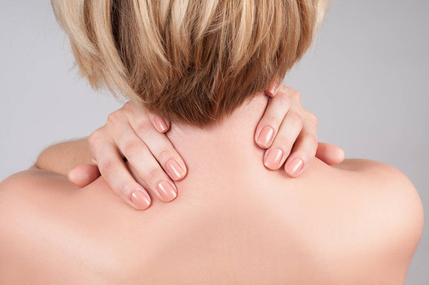 Young woman with shoulder pain, massaging her shoulder - Foto, Imagem