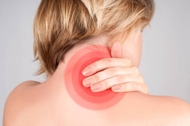 Young woman with neck pain, massaging her shoulder - Photo, image