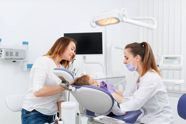 Dentists making treatment for little girl - Фото, изображение