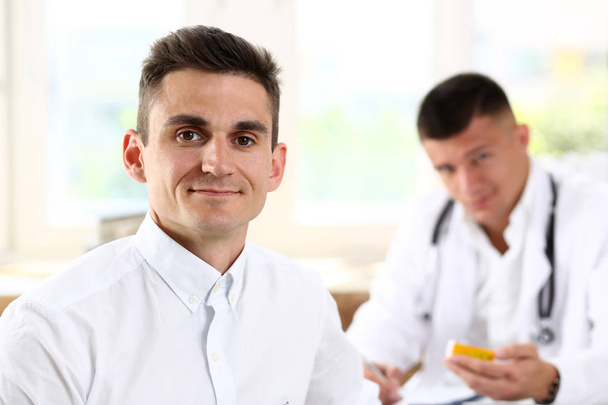 Ικανοποιημένοι ευτυχισμένη όμορφος χαμογελώντας άνδρα ασθενούς με το γιατρό - Φωτογραφία, εικόνα