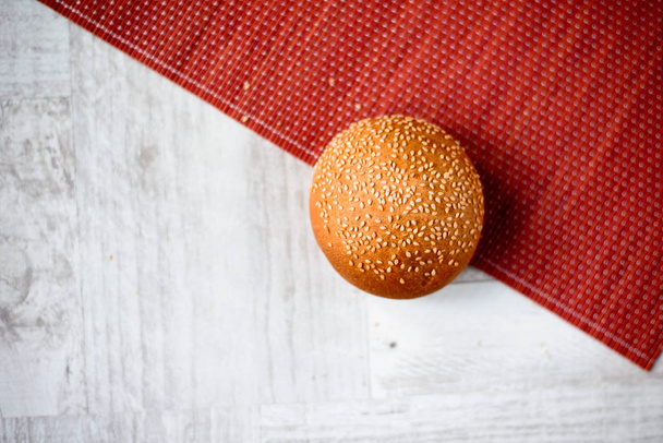 bun with sesame seeds on wooden table - Фото, зображення