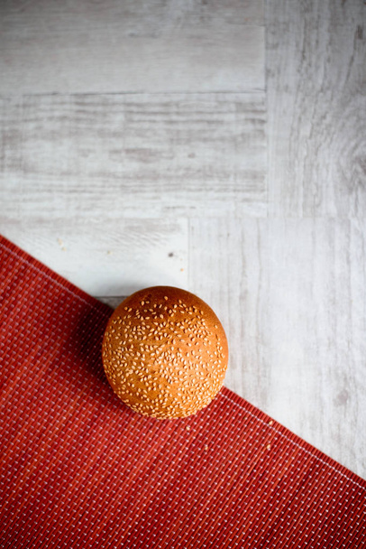 bun with sesame seeds on wooden table - 写真・画像
