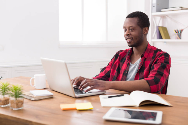 Empresário preto feliz no escritório casual, trabalhar com laptop
 - Foto, Imagem
