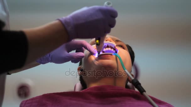 Installing the brackets on the teeth of a young female - Footage, Video