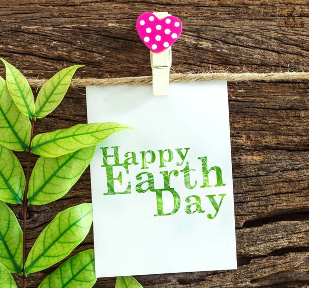 Happy Earth Day paper note hanging by red heart clips on wooden  - Photo, Image