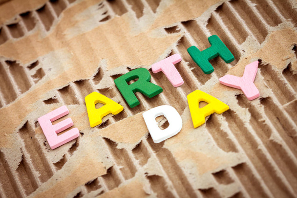 Earth Day Aufschrift auf abstrakten braunen zerrissenen Papphintergrund - Foto, Bild