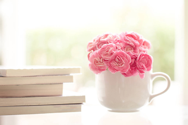 fresh pink carnation flower with books background - Photo, Image