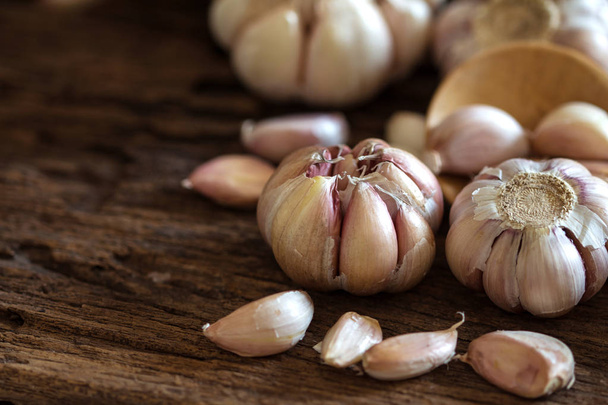 Close up the garlic bulb in bowl on wooden table  - Foto, afbeelding