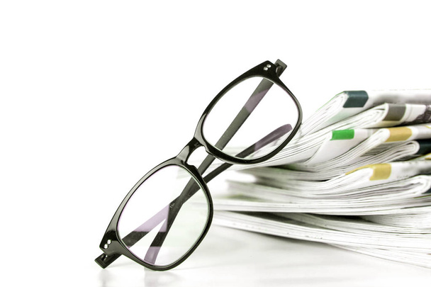 selective focus on reading eyeglasses with stacking of newspaper - Photo, Image