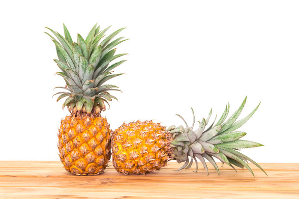  ovoce ananas na dřevěný stůl s bílou stěnu pozadí - Fotografie, Obrázek