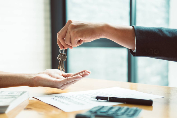estate agent giving house keys to man and sign agreement in offi - Photo, Image