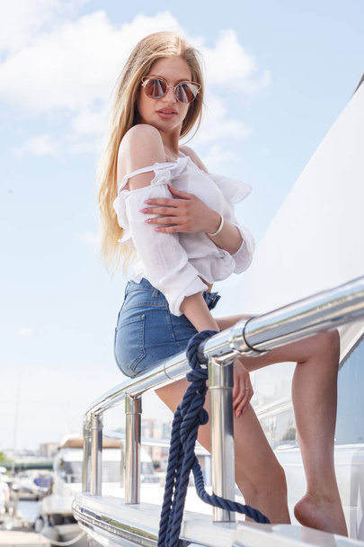 Beautiful woman posing near yacht - Фото, изображение