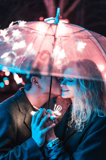 Ragazzo e ragazza baciare sotto un ombrello - Foto, immagini