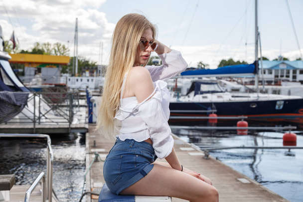 Beautiful young woman posing on pier - Foto, Imagen