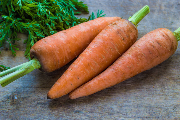 Молодая свежая морковь на деревянном фоне. Органические натуральные продукты питания
  - Фото, изображение