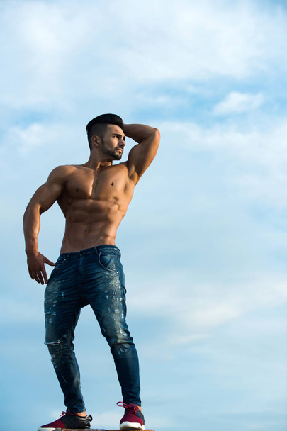 macho man with muscular body on blue sky - Foto, imagen