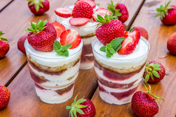 Cake met aardbeien en munt in beker (trifle) - Foto, afbeelding