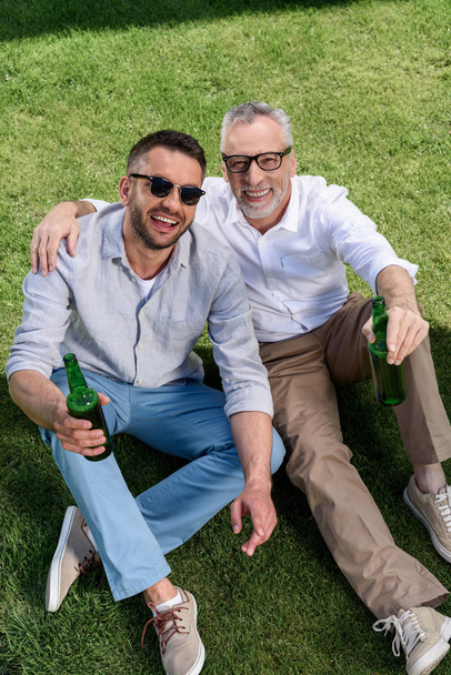father and adult son drinkig beer - Foto, afbeelding