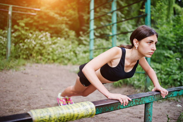 Sport girl at sportswear exercising at horizontal bar exercises  - Zdjęcie, obraz