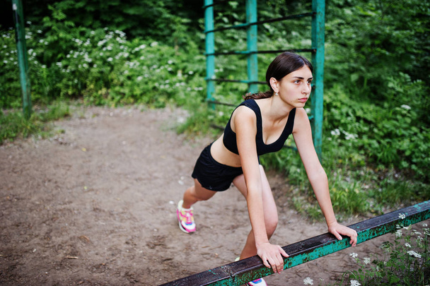 Sport girl at sportswear exercising at horizontal bar exercises  - Фото, зображення