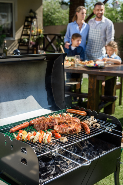 meat and vegetables cooking on grill - 写真・画像