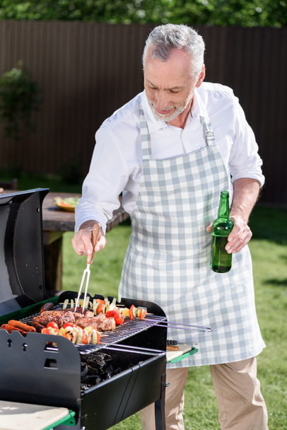 šedé vlasy-muž připravuje barbecue - Fotografie, Obrázek
