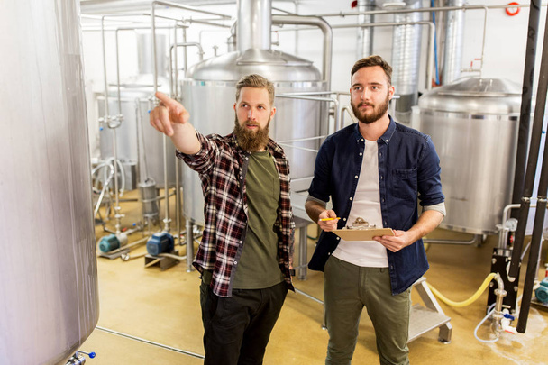 men with clipboard at craft brewery or beer plant - Foto, Imagen