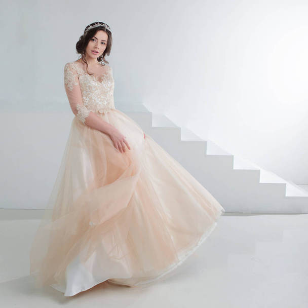 Portrait of a beautiful girl in a wedding dress. Bride in a luxurious dress, in a beautiful white interior - Foto, Imagen