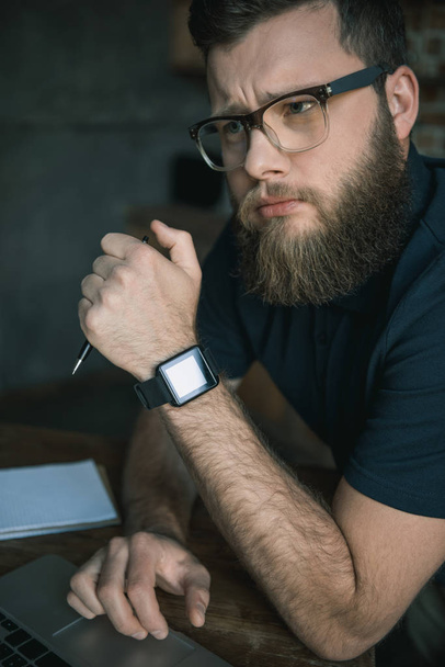 bearded man in eyeglasses during work - Foto, afbeelding