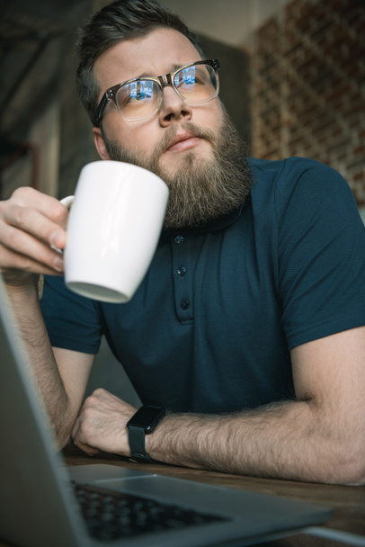 young bearded man drinking coffee - Fotoğraf, Görsel