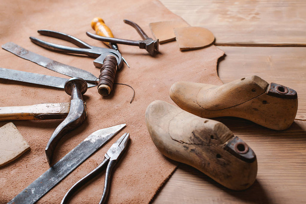 Cobbler tools in workshop on the wooden table . - Photo, Image