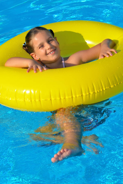 Adorable toddler relaxing in swimming pool - Foto, imagen