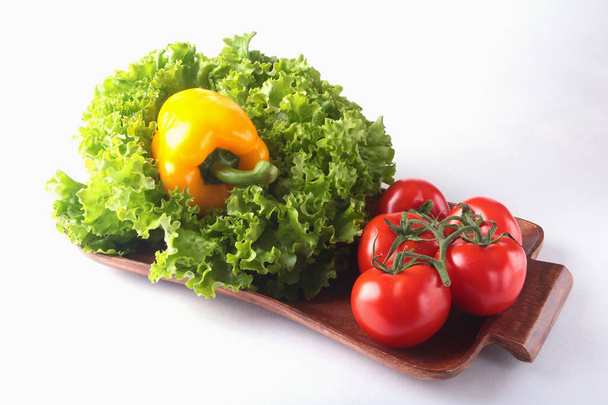 Fresh assorted vegetables bell pepper, tomato, garlic with leaf lettuce. Isolated on white background. Selective focus. - 写真・画像