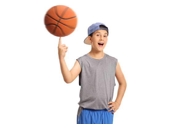 Joyful boy spinning a basketball on his finger - Foto, immagini