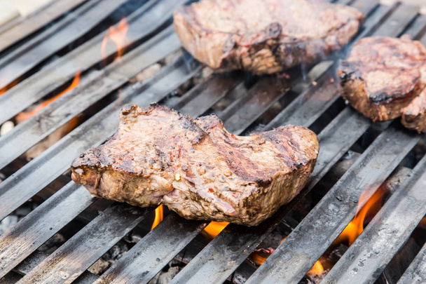 Rundvlees steak van de grill met vlammen. - Foto, afbeelding