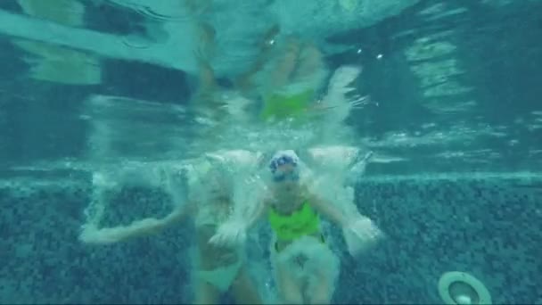 Dos niños están inmersos en el agua de la piscina. Movimiento lento
 - Imágenes, Vídeo