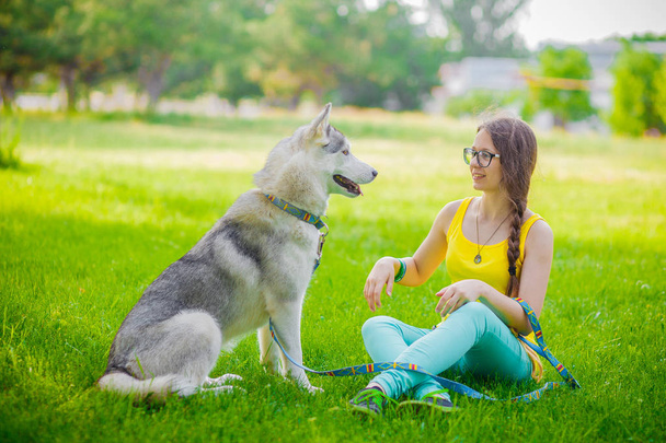 Beautiful young sportswoman taking a break from a workout to cuddle her dog pet - Foto, immagini