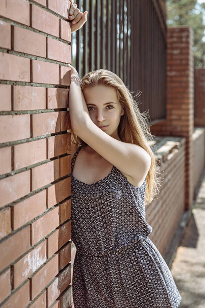 Beautiful teen girl on front brick wall - Photo, Image