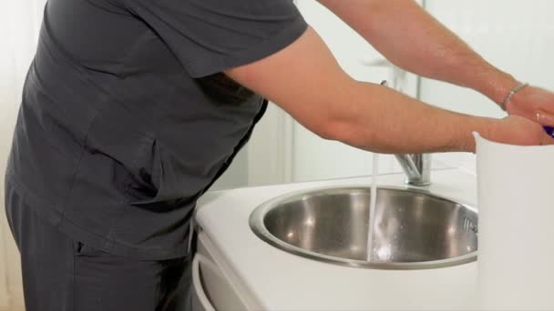 Дорослий лікар обережно миє руки, перш ніж надягати латексні рукавички
 - Кадри, відео