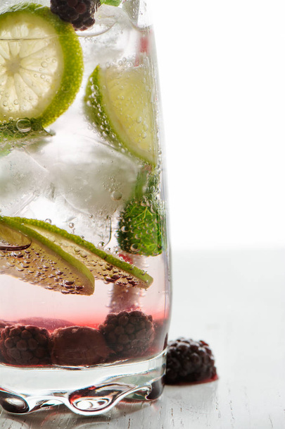 Gin Tonic mit Limette, Eis und roten Früchten - Foto, Bild