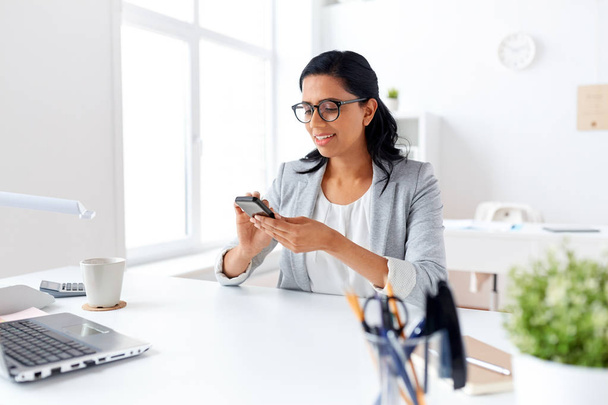 businesswoman messaging on smartphone at office - Photo, Image