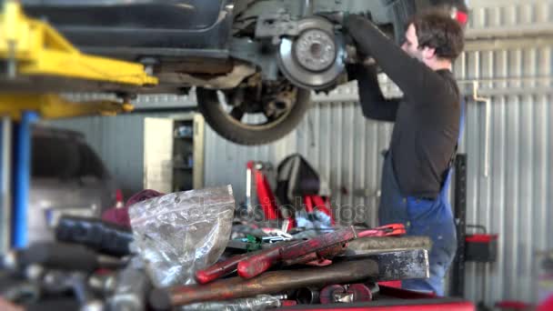 Vuile tools op vak en wazig mechanic man auto remsysteem herstellen. - Video
