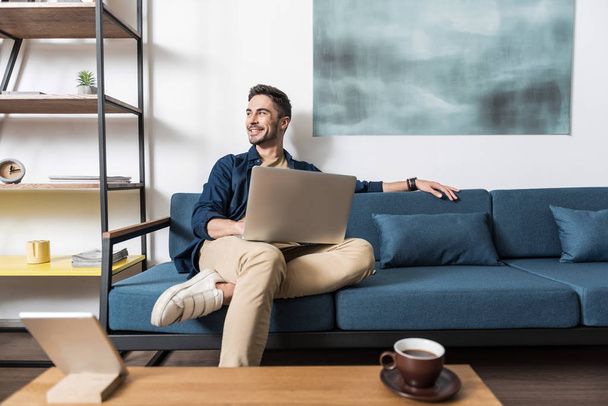 Happy youthful guy working at home via computer - Photo, image