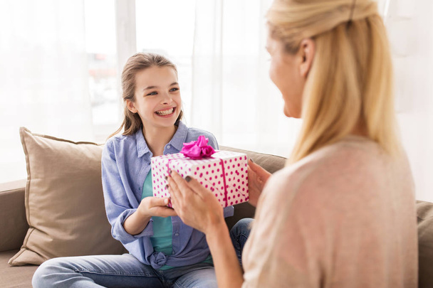 girl giving birthday present to mother at home - Photo, Image