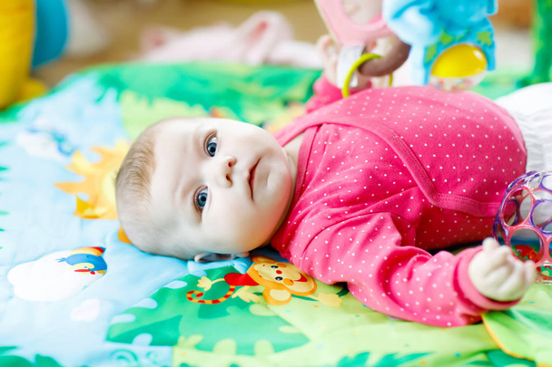 Cute adorable newborn baby playing on colorful toy gym - Photo, Image