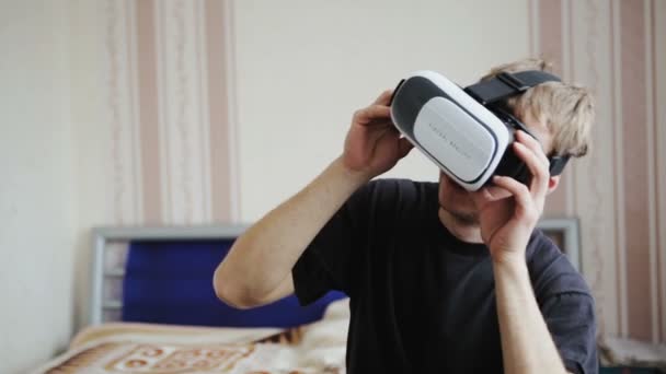 Genç adam VR-kask kullanarak bir oyun oynuyor - Video, Çekim